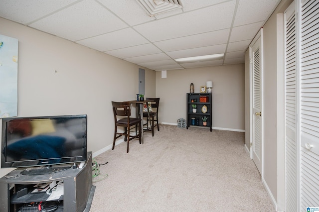 sitting room featuring light carpet and a drop ceiling