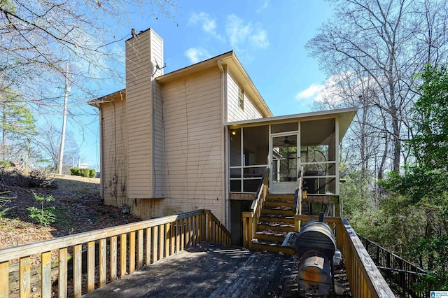 back of property featuring a deck and a sunroom