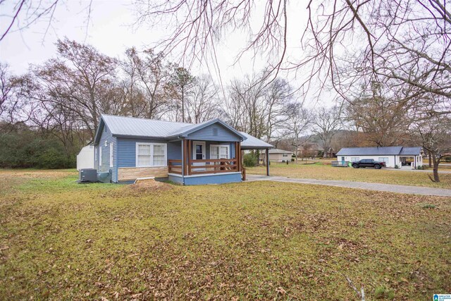 view of front of property featuring a carport, a porch, and a front yard