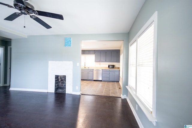 unfurnished living room featuring ceiling fan and dark wood-type flooring