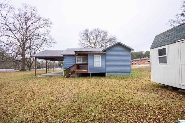 rear view of property featuring a yard and a carport