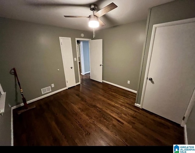 unfurnished bedroom featuring ceiling fan and dark hardwood / wood-style flooring