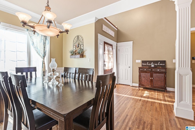 dining area featuring decorative columns, light hardwood / wood-style flooring, and ornamental molding