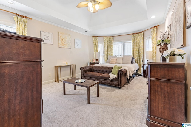 carpeted bedroom featuring a tray ceiling, ceiling fan, and ornamental molding