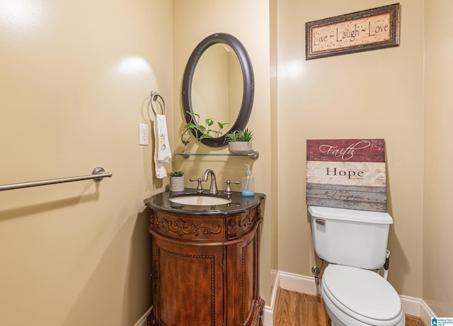 bathroom featuring wood-type flooring, vanity, and toilet