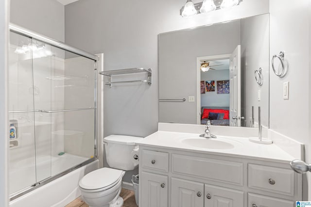 full bathroom with shower / bath combination with glass door, vanity, toilet, and ceiling fan