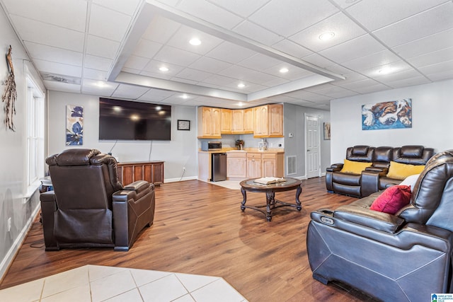 living room with a raised ceiling and light hardwood / wood-style flooring