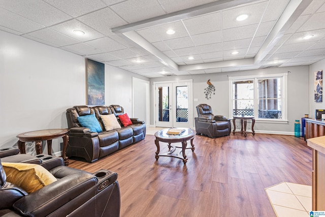 living room featuring wood-type flooring and a drop ceiling