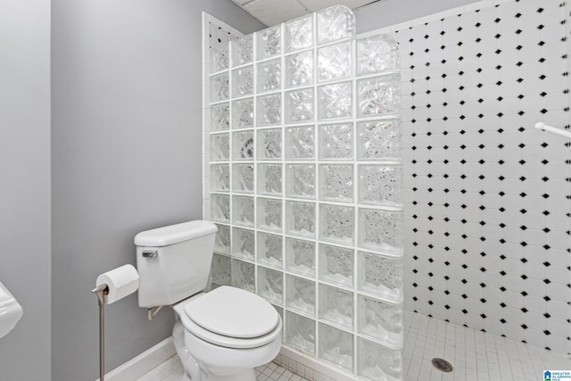 bathroom featuring tile patterned flooring, toilet, and a shower