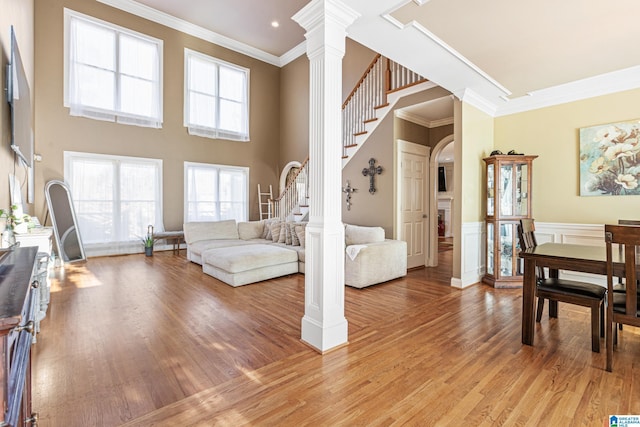 living room with decorative columns, hardwood / wood-style flooring, and ornamental molding