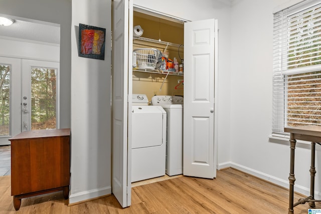 laundry room featuring french doors, crown molding, washer and dryer, a textured ceiling, and light hardwood / wood-style floors