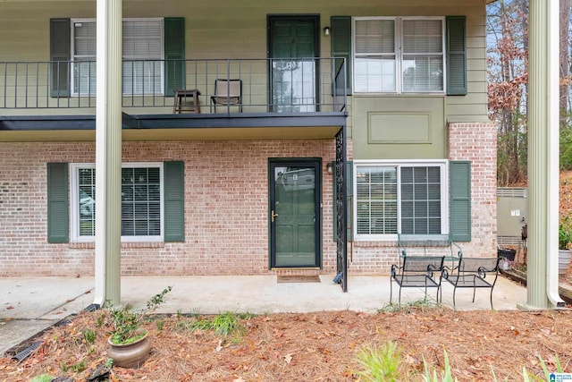 view of exterior entry featuring a balcony