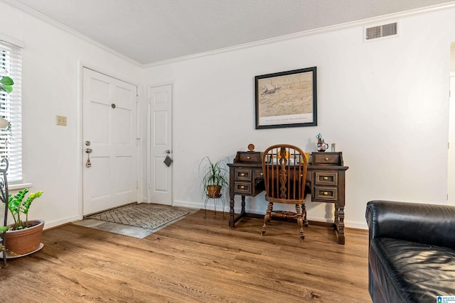 foyer featuring hardwood / wood-style flooring and crown molding