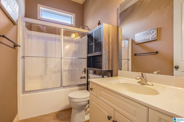 full bathroom featuring shower / bath combination with glass door, tile patterned flooring, vanity, and toilet