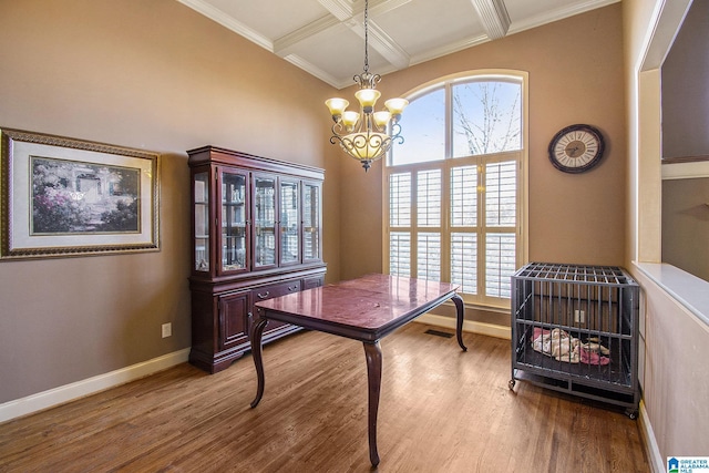 office with coffered ceiling, hardwood / wood-style flooring, ornamental molding, beamed ceiling, and a chandelier