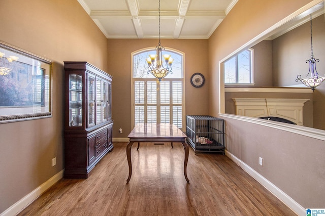 interior space featuring a healthy amount of sunlight, light wood-type flooring, beam ceiling, and a chandelier