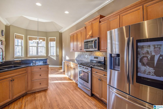 kitchen with a notable chandelier, vaulted ceiling, decorative light fixtures, decorative backsplash, and appliances with stainless steel finishes