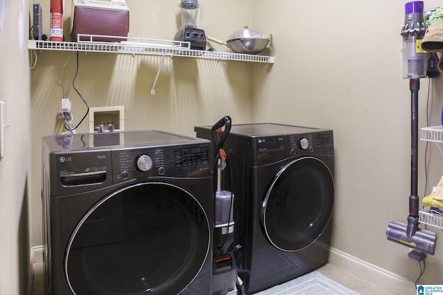 washroom with laundry area, baseboards, and washing machine and clothes dryer