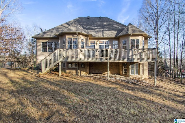 back of property with a yard, a wooden deck, and stairs