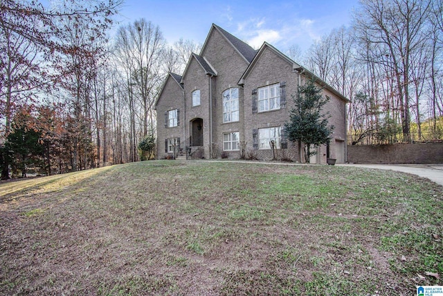 view of front of property featuring a front lawn and brick siding