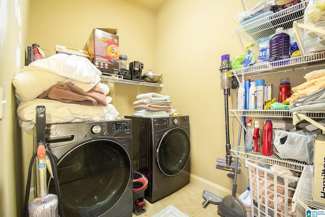 laundry area with washer and clothes dryer and light tile patterned floors