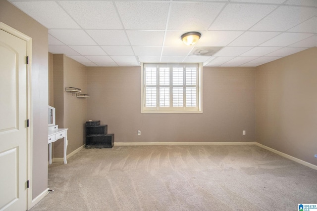 interior space with a drop ceiling and light colored carpet