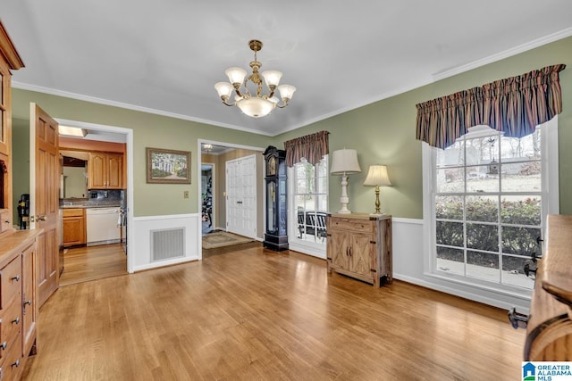 interior space featuring light hardwood / wood-style floors, crown molding, and a notable chandelier