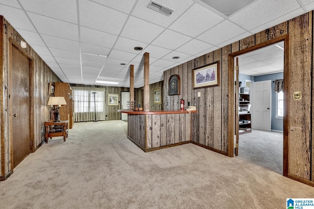 bar featuring wood walls and light colored carpet