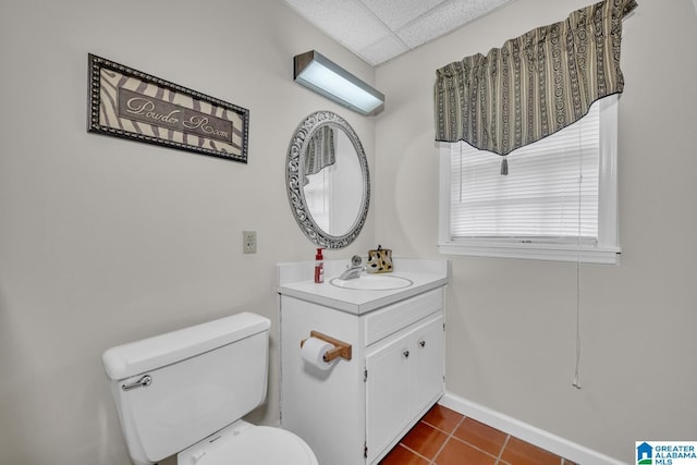 bathroom featuring tile patterned floors, a paneled ceiling, vanity, and toilet