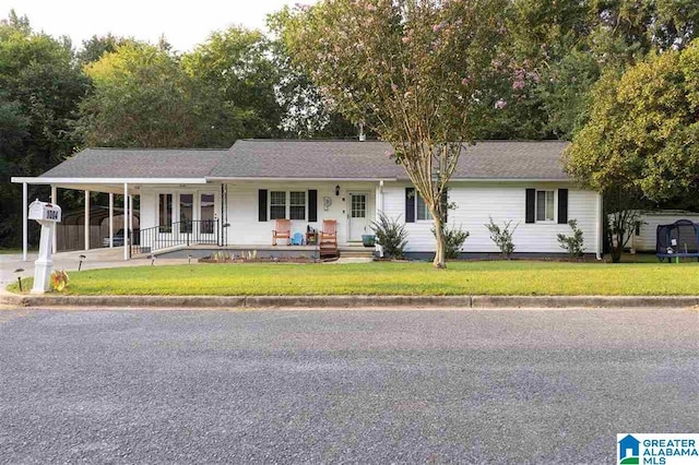 ranch-style home featuring a carport and a front lawn