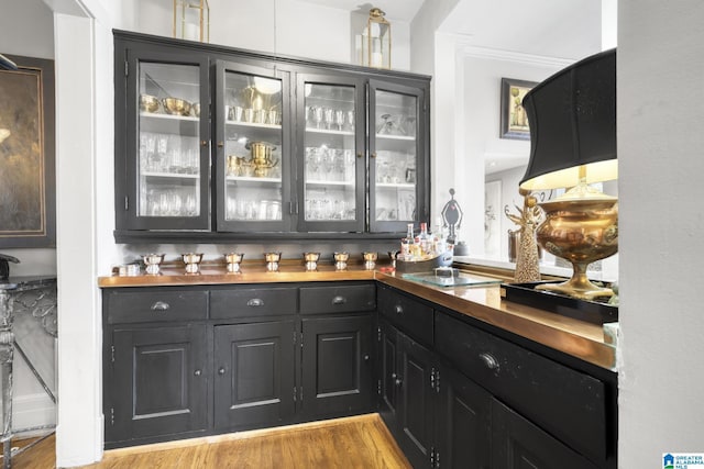 bar featuring light hardwood / wood-style floors and ornamental molding