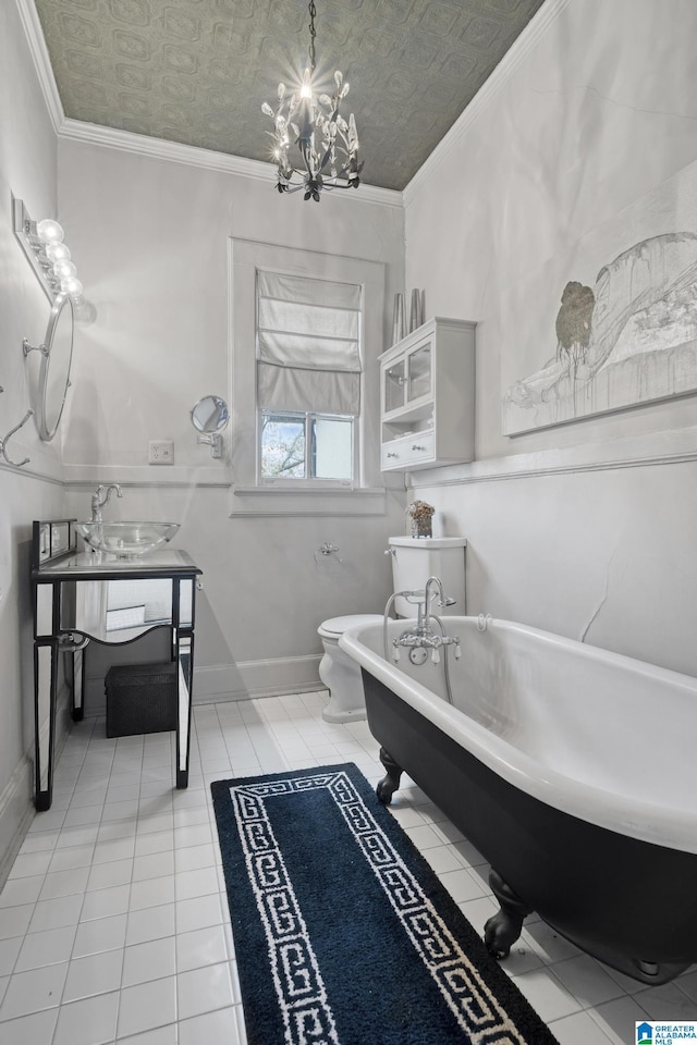 bathroom featuring crown molding, an inviting chandelier, tile patterned flooring, toilet, and a bathing tub