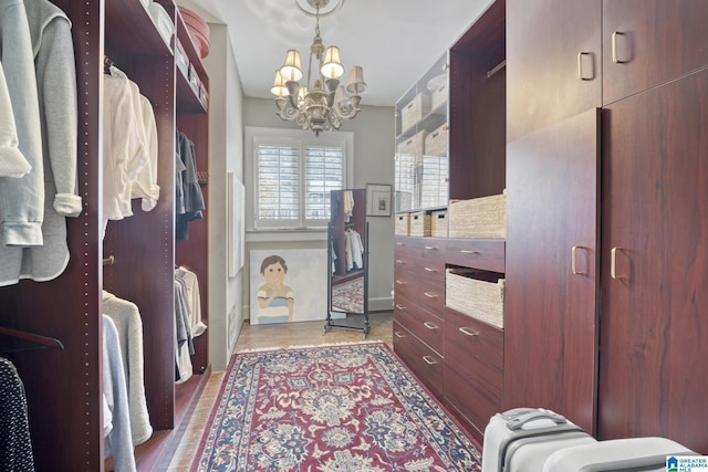 walk in closet with a notable chandelier and dark hardwood / wood-style floors