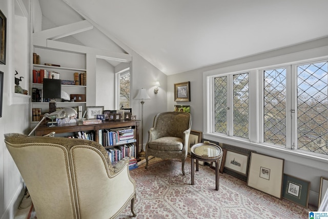 sitting room featuring built in features and vaulted ceiling