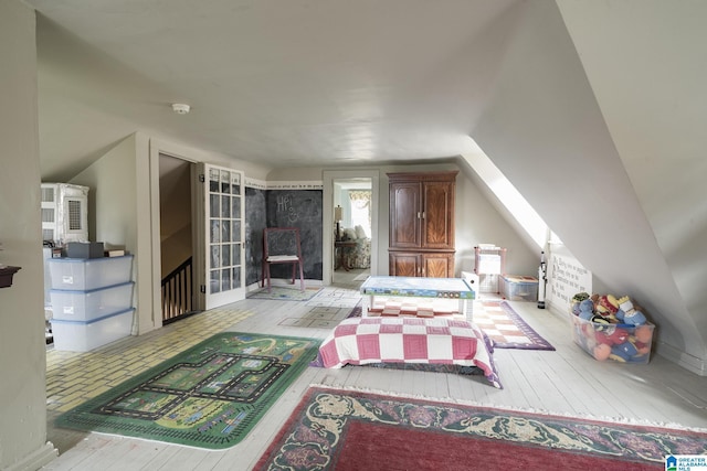 bedroom with vaulted ceiling and light hardwood / wood-style flooring