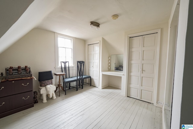 sitting room with light hardwood / wood-style floors and vaulted ceiling