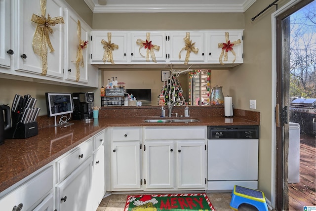 kitchen with white dishwasher, white cabinets, sink, dark stone countertops, and ornamental molding