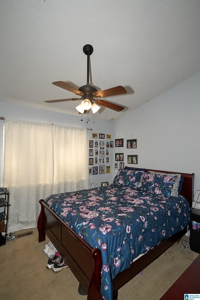 carpeted bedroom featuring a textured ceiling, vaulted ceiling, and ceiling fan