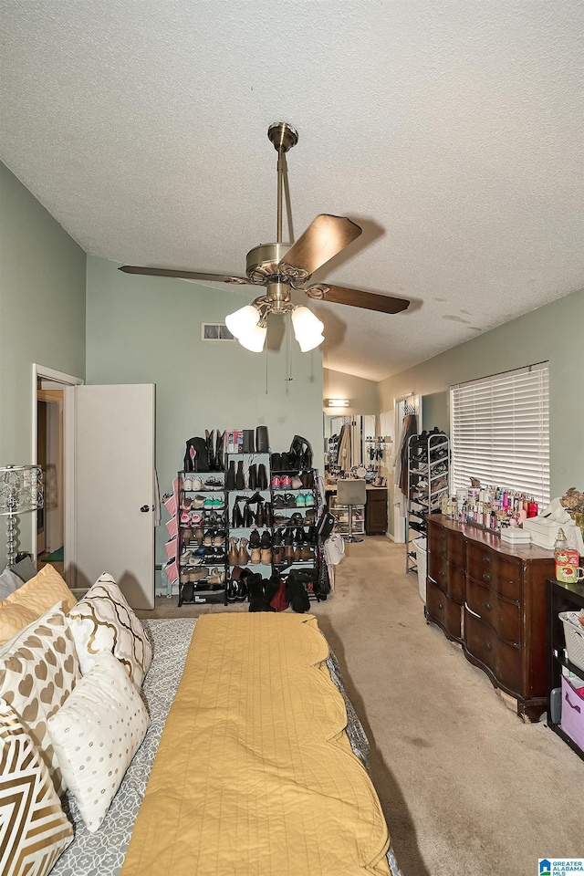 bedroom featuring light carpet, a textured ceiling, and ceiling fan