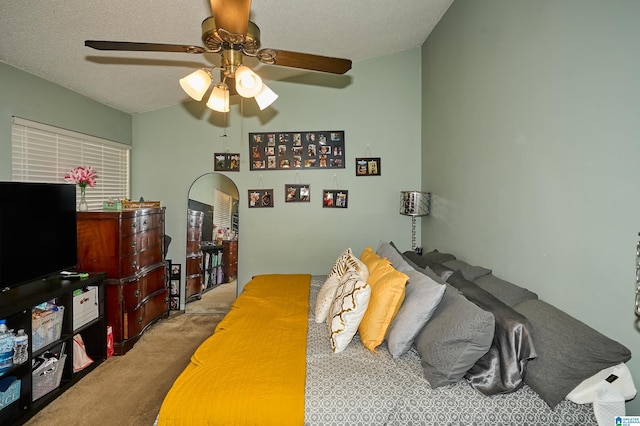 bedroom featuring ceiling fan, carpet floors, and a textured ceiling