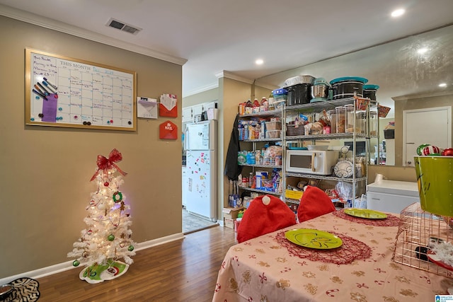 dining space with wood-type flooring and crown molding