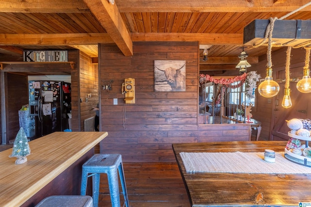 unfurnished dining area with beamed ceiling, wooden walls, and wood ceiling