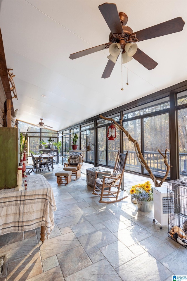 sunroom / solarium with lofted ceiling and a ceiling fan