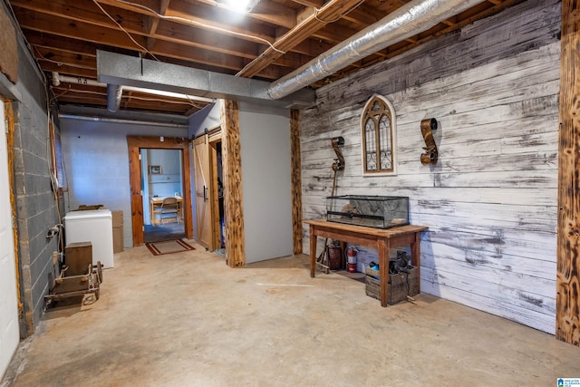 basement featuring fridge and wooden walls