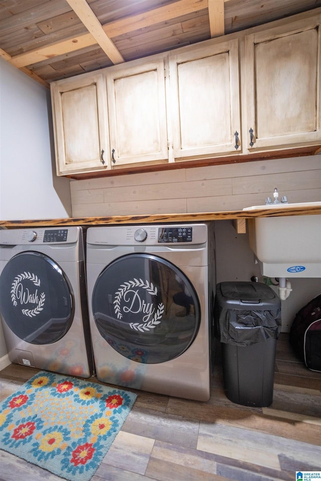 laundry area featuring wood ceiling, separate washer and dryer, wood finished floors, cabinet space, and a sink