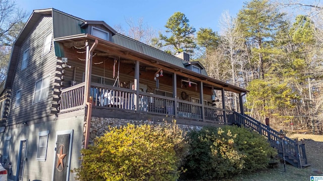 exterior space with stairway, log siding, a porch, and metal roof