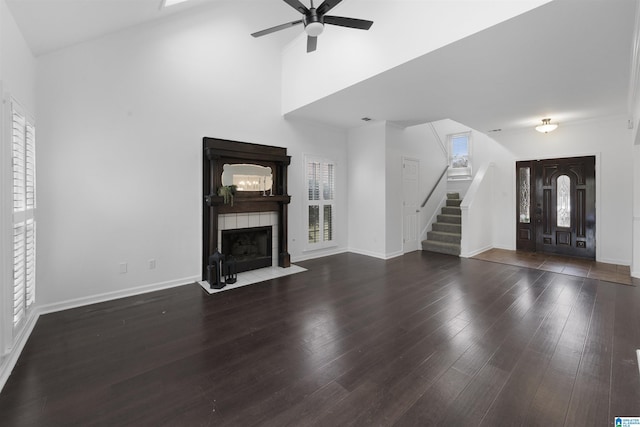 unfurnished living room featuring ceiling fan, a fireplace, high vaulted ceiling, and dark hardwood / wood-style floors