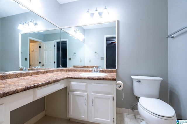 bathroom featuring tile patterned flooring, vanity, and toilet