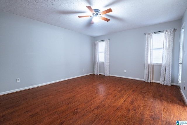 spare room with dark hardwood / wood-style floors, ceiling fan, and a textured ceiling