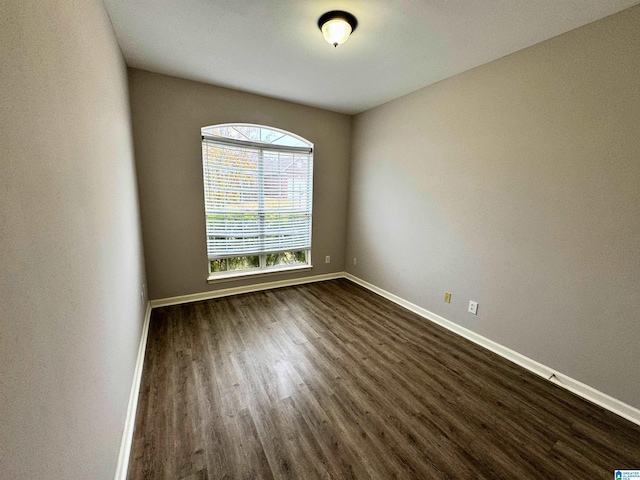 unfurnished room with dark wood-type flooring